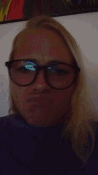 a woman wearing glasses is making a face