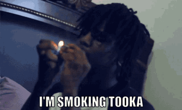 a man is lighting a cigarette with the words i 'm smoking tooka below him