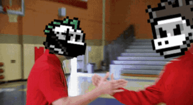 a man in a red shirt is shaking hands with another man with a pixelated face on his head