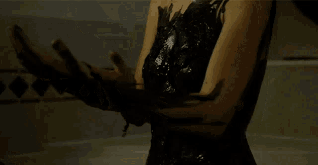 a woman in a black dress has black paint on her arms