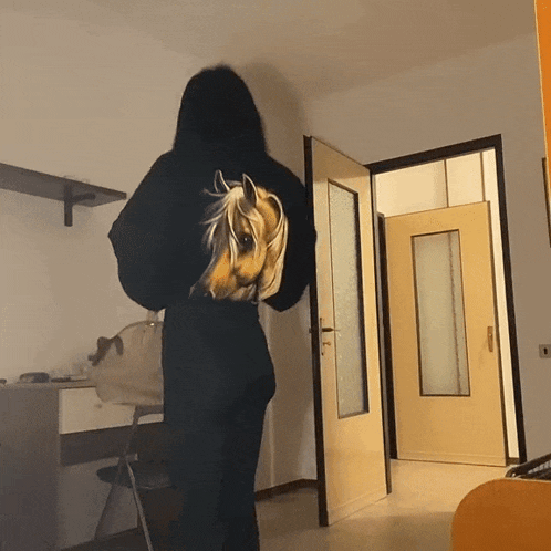 a woman wearing a black hoodie with a horse on it