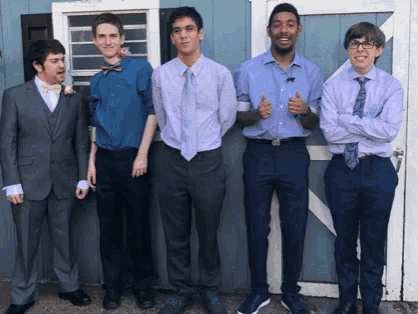 a group of young men in suits and ties pose for a photo