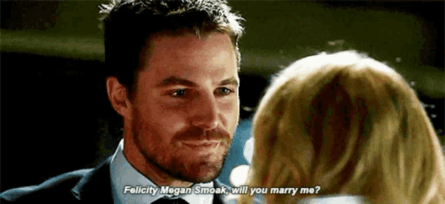 felicity megan smoak will you marry me ? is being asked by a man in a suit .