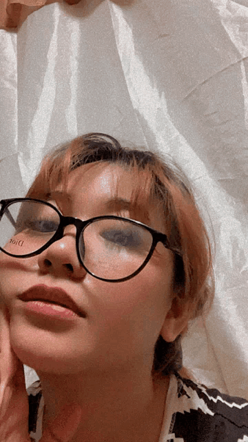 a woman wearing glasses has the word dior on her face