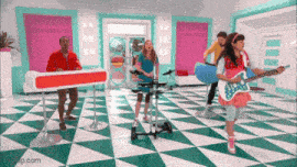 a group of people are playing instruments in a room with a checkered floor and a girl is playing guitar