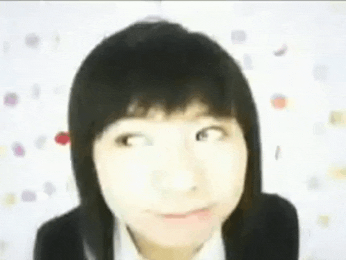 a close up of a girl making a funny face against a white background .