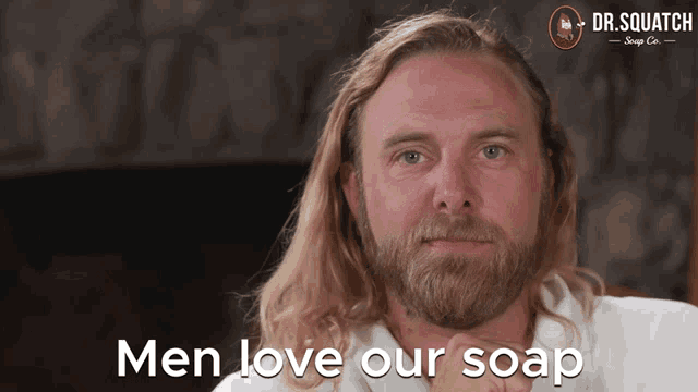 a man with long blonde hair and a beard says " men love our soap "