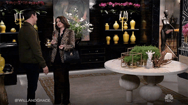 a man and a woman are standing in a room with nbc written on the bottom of the screen