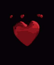 a red heart is surrounded by smaller red hearts on a black background .