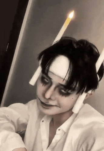 a man with a bandage on his head has two candles in his hair