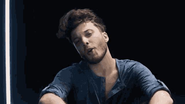 a man with a beard is making a funny face with his hands in the air .