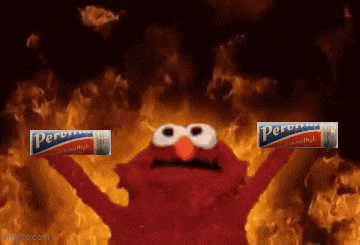 elmo is holding up a pack of peroxide in front of flames