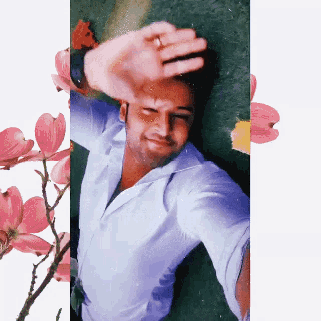 a man in a white shirt is laying on the ground with his hand on his face