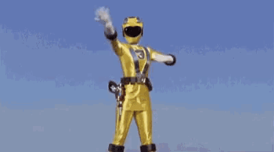 a yellow power ranger is standing in the rain with his arms in the air .