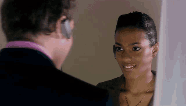a man and a woman are looking at each other and smiling