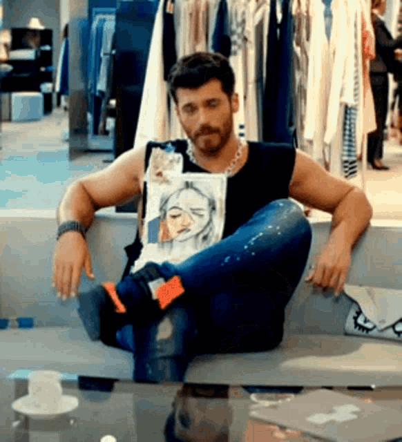a man is sitting on a couch with his legs crossed and holding a drawing of a woman .