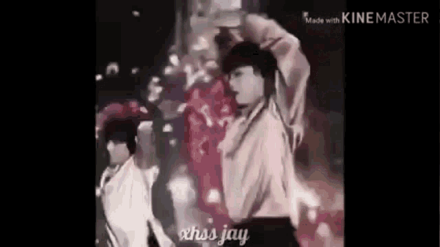 a man in a white shirt is dancing on a stage with a pink background .