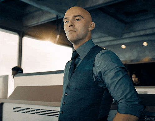 a bald man in a suit and tie stands in front of a kepler logo