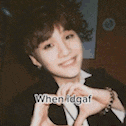 a young boy is making a heart shape with his hands and smiling .