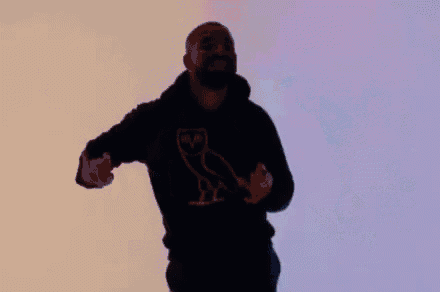 a man wearing a black hoodie with an owl on it is dancing in the air .