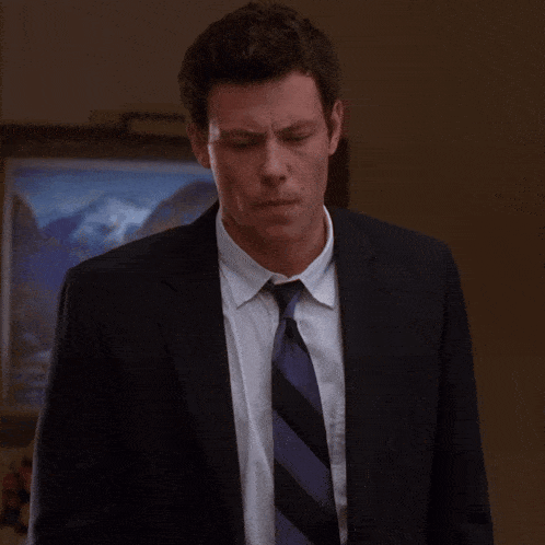 a man in a suit and tie is looking down
