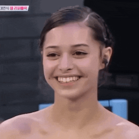 a woman without a shirt is smiling in front of a sign that says ' korean ' on it
