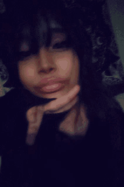 a blurry picture of a woman making a face with her hand