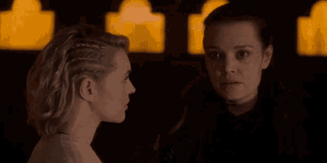 two women look at each other in the dark