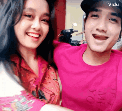 a man wearing a pink shirt that says time to meet you smiles with a woman