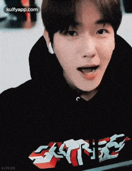 a close up of a person wearing a black hoodie with a red and white graphic on it .
