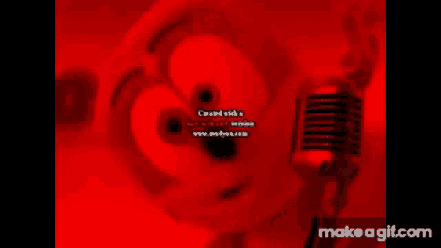 a gummy bear is singing into a microphone in a red background .