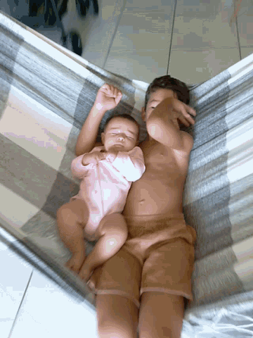 a man laying in a hammock with a baby