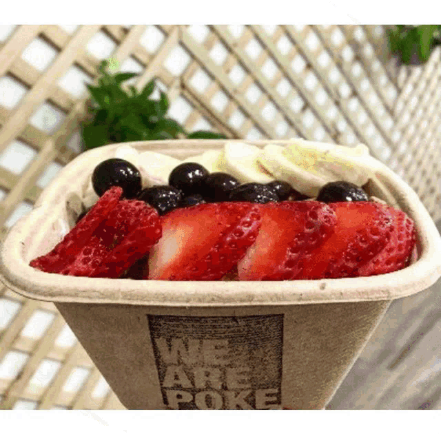 a bowl of fruit with the words we are poke on the side