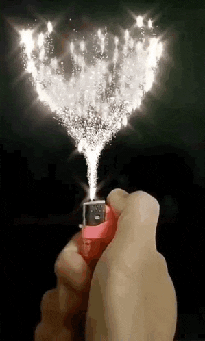 a person is holding a lighter with fire coming out of it in their hand .