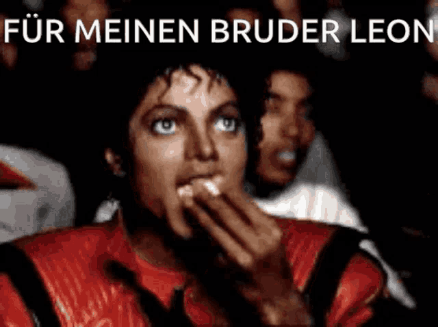 a man in a red jacket is eating something in front of a crowd with the words für meinen bruder leon above him