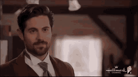 a man in a suit and tie is smiling in a hallmark channel advertisement