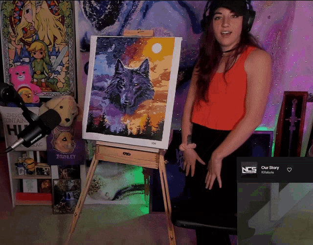 a woman stands in front of an easel with a painting of a wolf