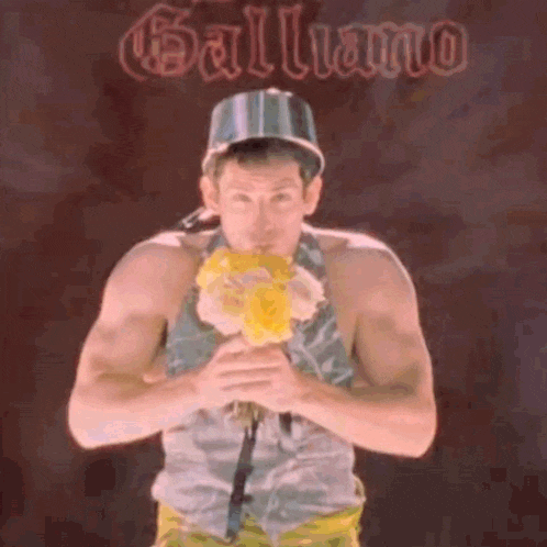 a man is holding a bouquet of flowers in front of a sign that says galliano