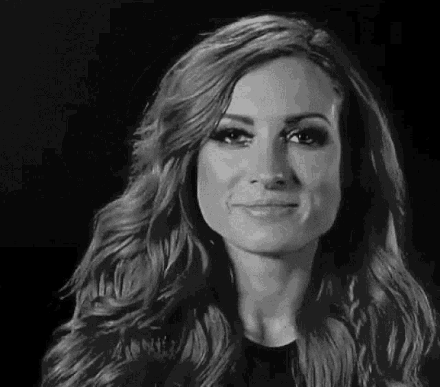 a black and white photo of a woman with long red hair smiling .