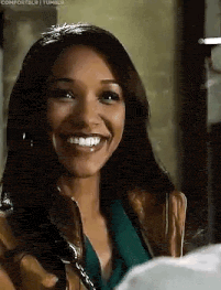 a woman is smiling and looking at the camera while wearing a brown jacket .