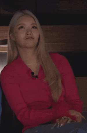 a woman in a red shirt is sitting in a chair