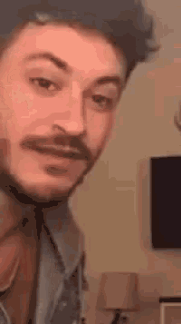 a man with a beard is making a funny face .