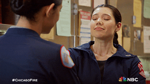 two female firefighters are standing next to each other with their eyes closed and #chicagofire written on the bottom