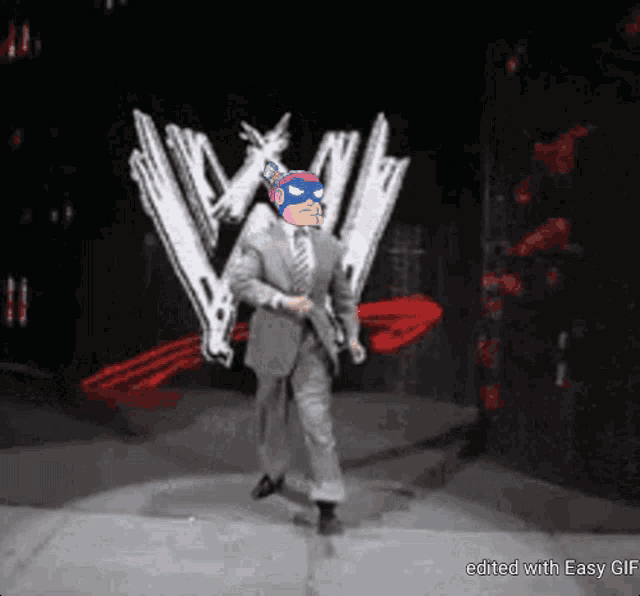 a man in a suit and tie is dancing in front of a wrestling logo