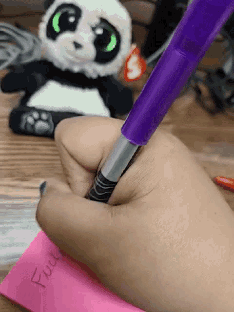 a person is writing on a pink piece of paper that says " full "