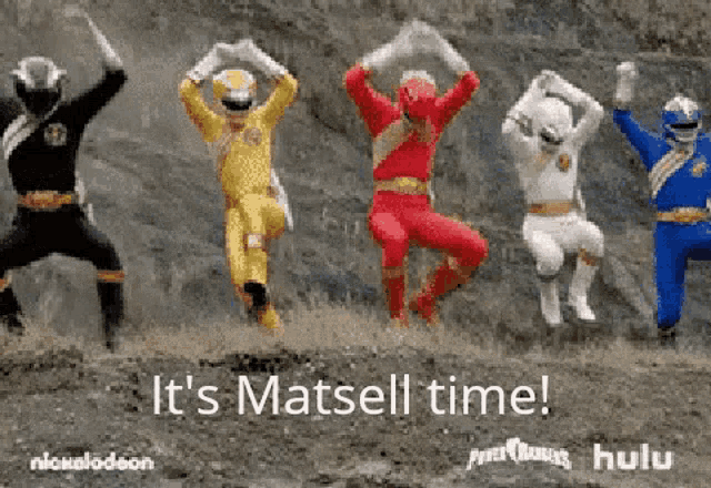 a group of power rangers are standing next to each other in a field .