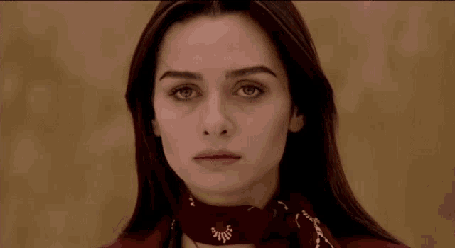 a close up of a woman wearing a red scarf around her neck