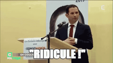 a man in a suit and tie is giving a speech at a podium and the word ridicule is on the screen