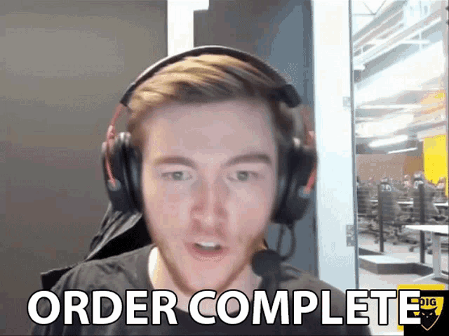 a man wearing headphones says " order complete " in front of him
