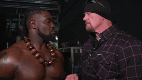 a man in a purple plaid shirt stands next to another man